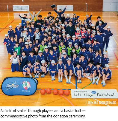 Photo:A circle of smiles through players and a basketball —commemorative photo from the donation ceremony.